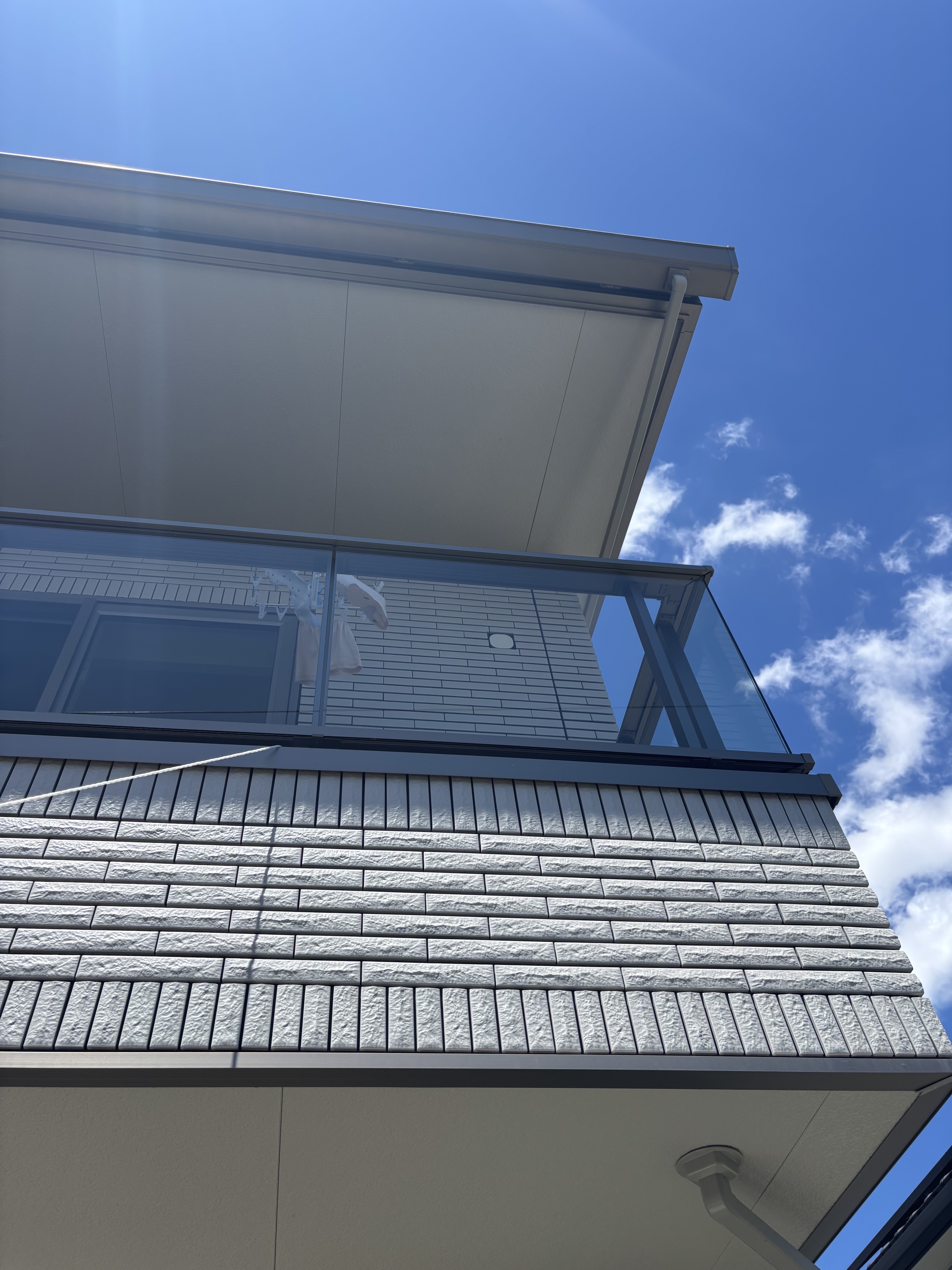 青空を背景に下から見上げた、一条工務店の軒を延長した屋根